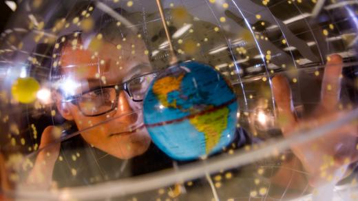 Student looking at globe